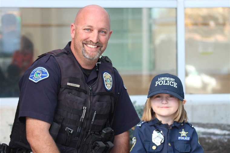 Sidney Fahrenbruch, 4, posed alongside Longmont Police Officer David Bonday, who helped the little girl by checking for monsters on an earlier visit.