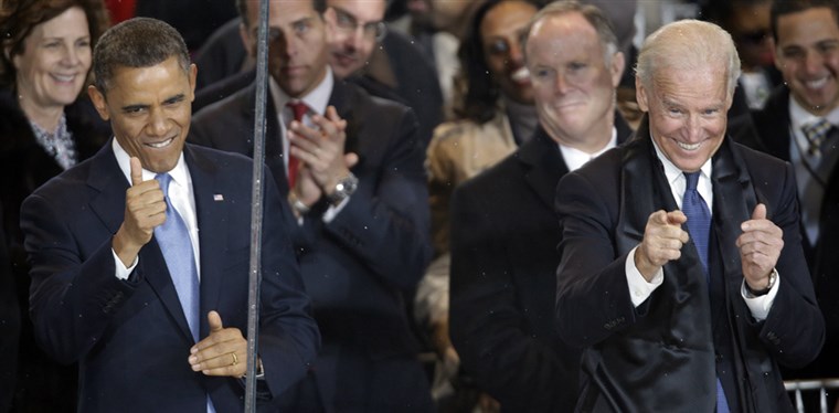 Вице President Joe Biden gives the thumbs up and the finger point as he and President Barack Obama react during the inaugural parade on Pennsylvania Avenue near the White House on Monday.