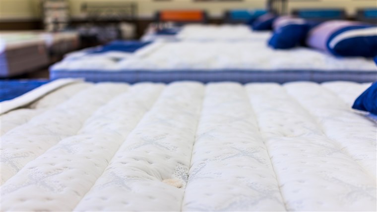 A închide of many mattresses on display in store
