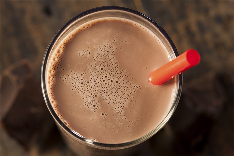 Šokoladas milk on a glass with red straw
