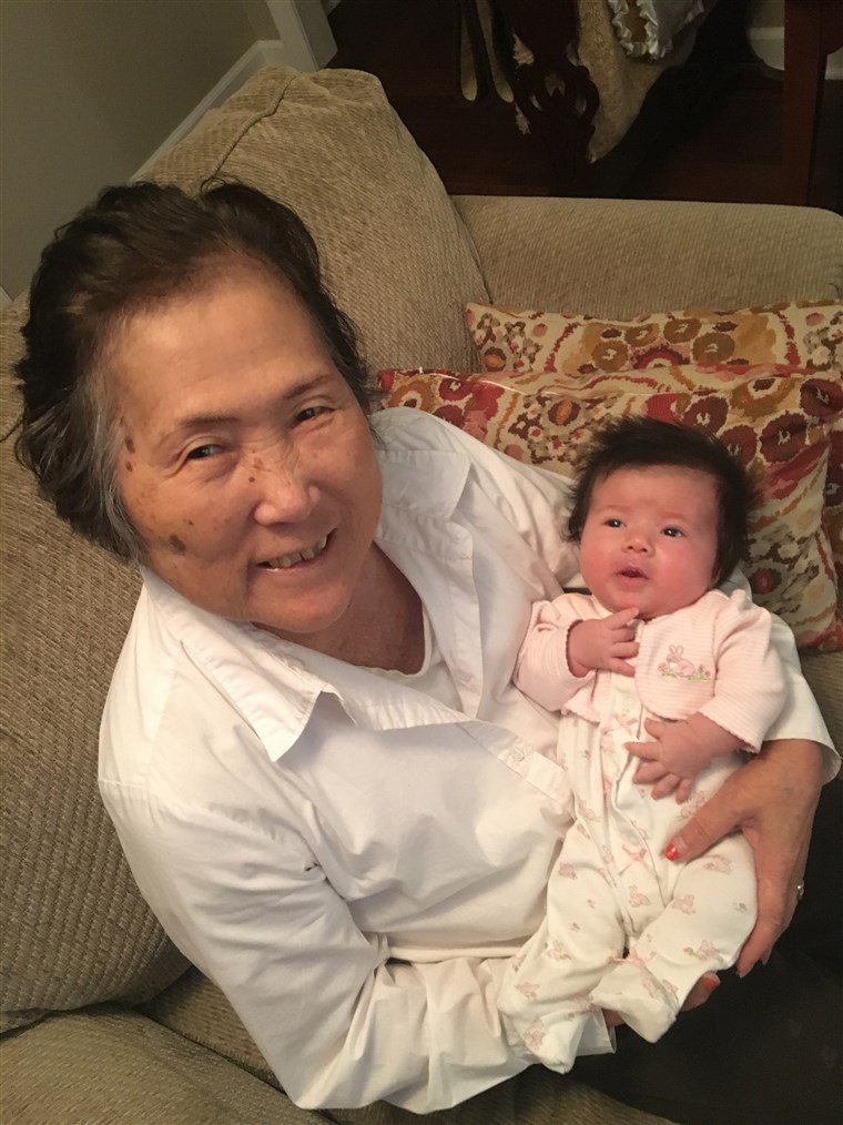 Алзхеимер's patient Setsuko Harmon cradles her granddaughter Sadie.