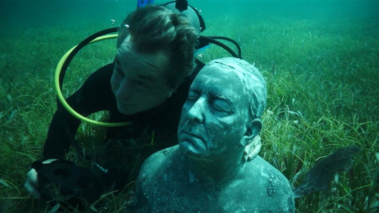 Слика: Kerry Sanders poses under water with his sculpture