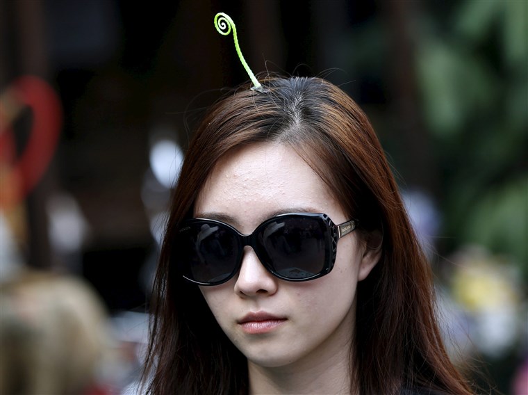 en woman wearing a sprout-like hairpin makes her way on Nanluoguxiang street in Beijing