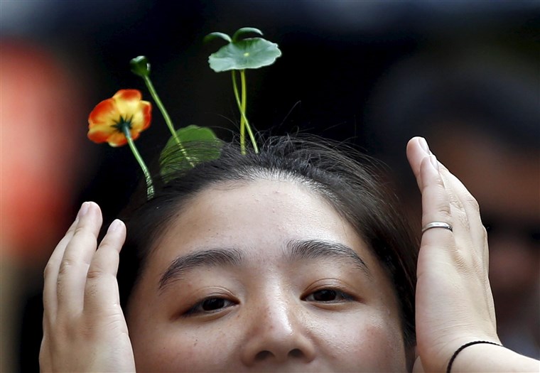 en woman wearing hairpins in the shape of sprouts and flowers makes her way on Nanluoguxiang street in Beijing
