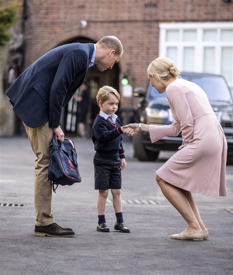 Britanija's Prince George accompanied by Britain's Prince William (L), Duke of Cambridge arrives for his first day of school.