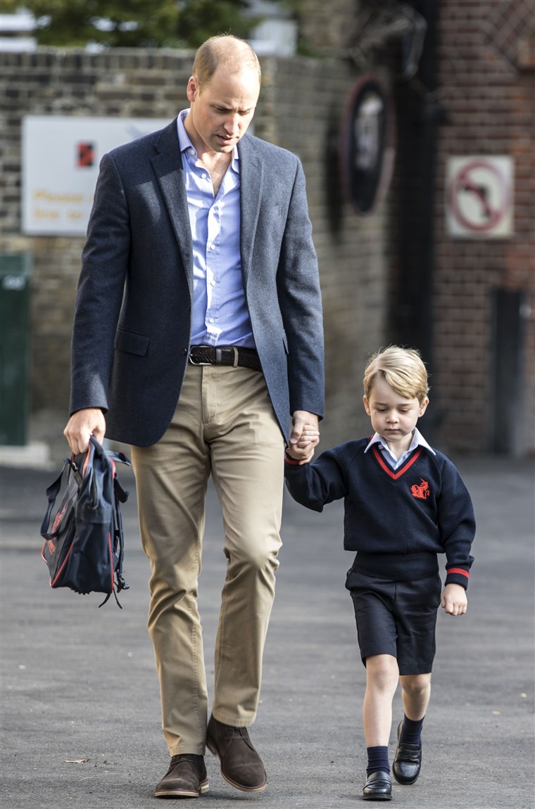 Britanija's Prince George accompanied by Britain's Prince William (L), Duke of Cambridge arrives for his first day of school.