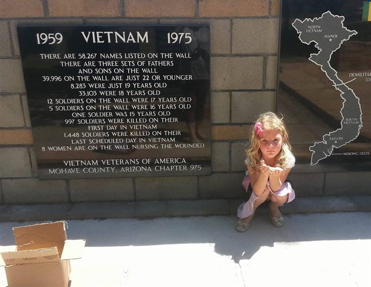 Бренди Phillips' 4-year-old daughter, Serenity Hopkins, prepares to hide a painted rock at a memorial site.