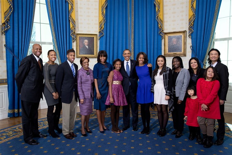 Prezidentas Barack Obama, first lady Michelle Obama, and daughters Sasha and Malia, center, join their extended family for a group photo in the Blue Room of the White House on Inauguration Day, Sunday, Jan. 20, 2013. Joining the First Family from left are: Craig Robinson, Leslie Robinson, Avery Robinson, Marian Robinson, Akinyi Manners, Auma Obama, Maya Soetoro-Ng, Konrad Ng, Savita Ng, and Suhaila Ng.