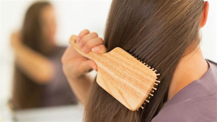 Жена brushing hair
